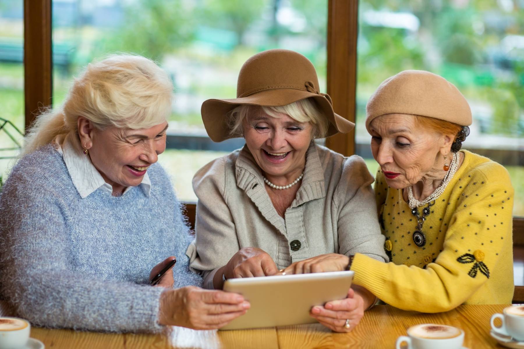 Senior women with tablet Smiling ladies at cafe table